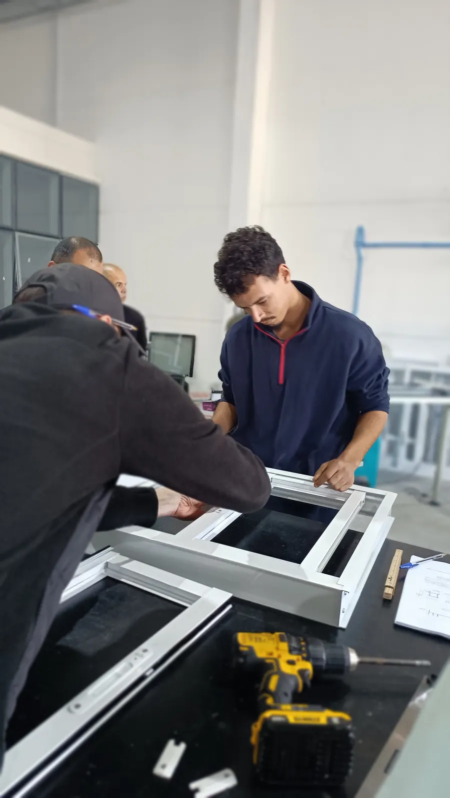 Turma acompanhando a fabricação de uma esquadria de PVC na bancada