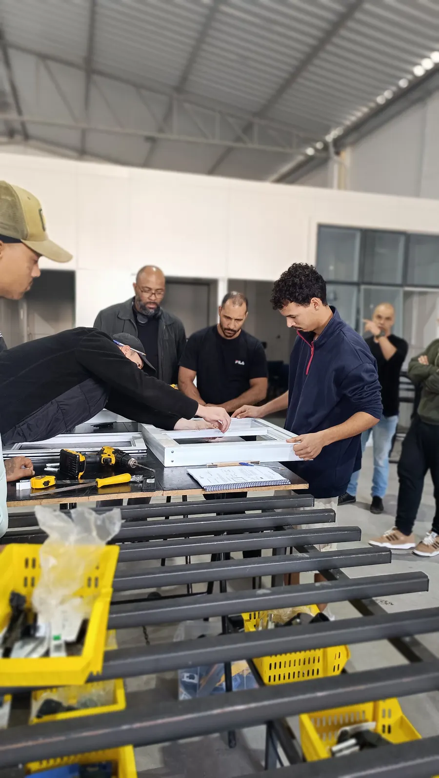 Participantes analisando perfis e componentes de esquadrias de PVC na imersão
